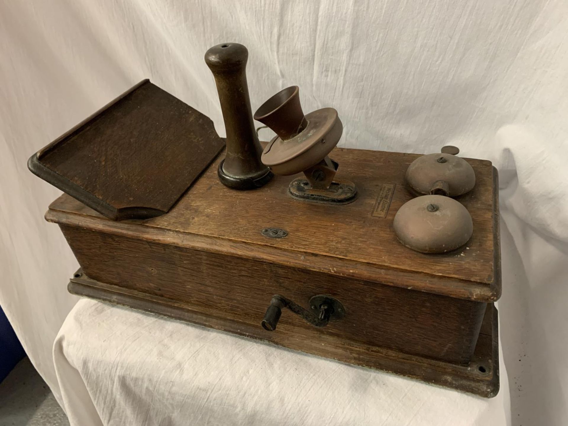 A VINTAGE TELEPHONE WITH DAFFODIL HANDSET AND METAL DOMED BELLS IN AN OAK WALL CASE