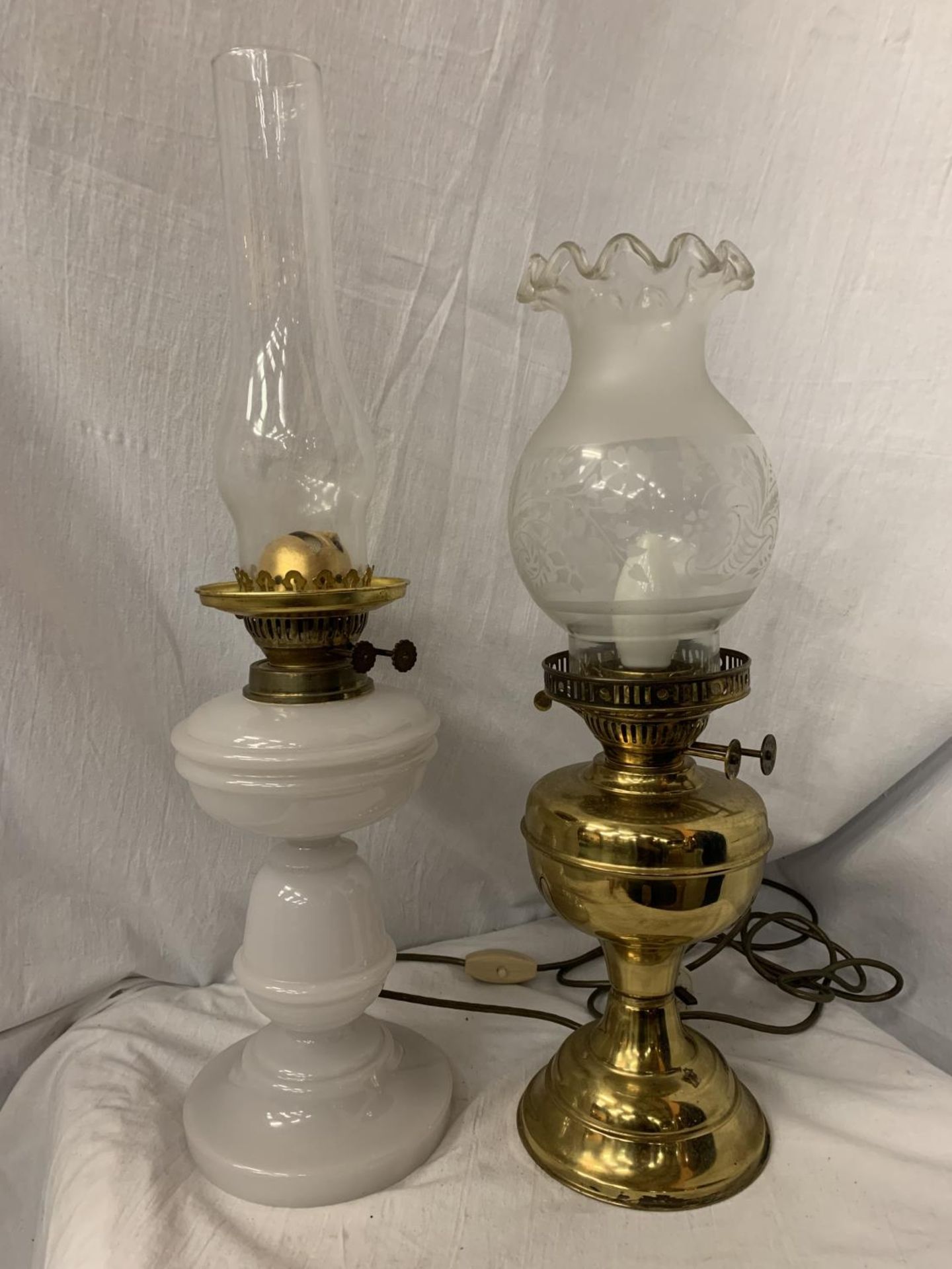 TWO OIL LAMPS, ONE WITH A WHITE GLASS BASE AND THE OTHER A BRASS EXAMPLE