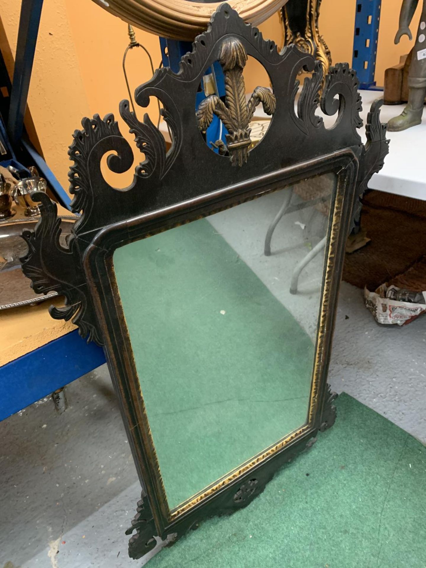 A LARGE MAHOGANY FRAMED MIRROR WITH CARVED DETAIL AND FLEUR DE LIS DECORATION