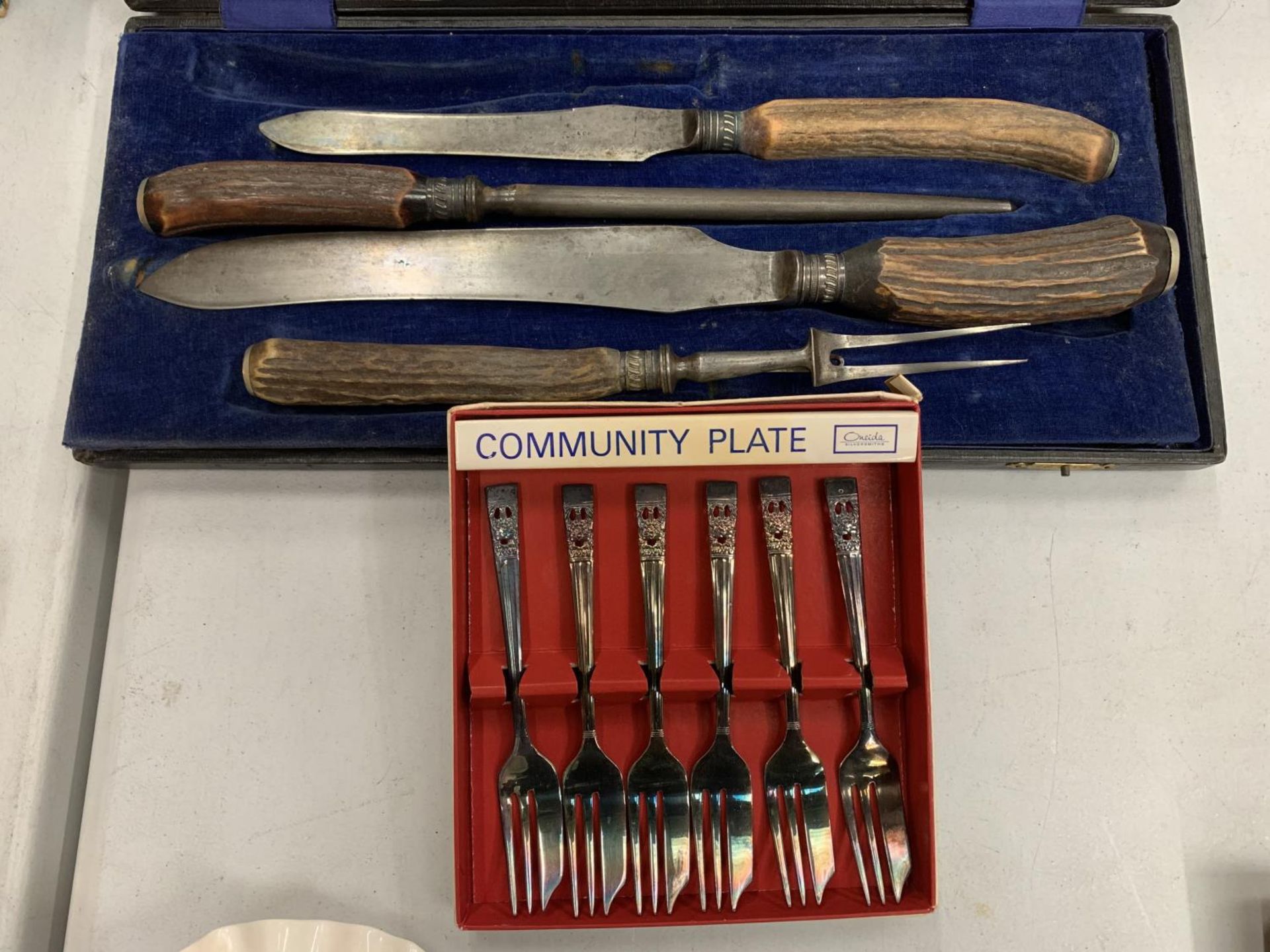 A VINTAGE BOXED MEAT CARVING SET AND SIX BOXED COMMUNITY PLATE CAKE FORKS