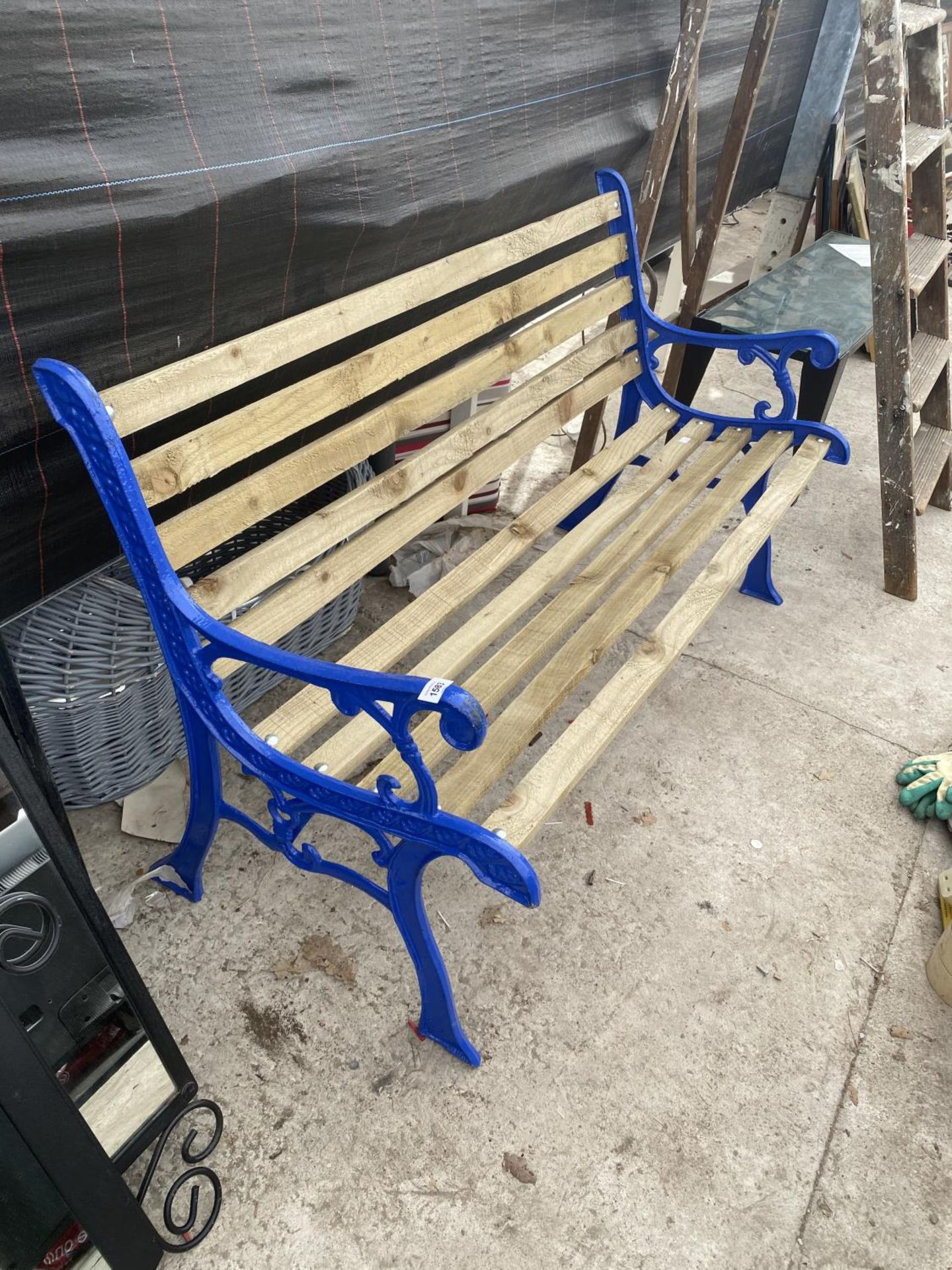A WOODEN SLATTED GARDEN BENCH WITH CAST IRON BENCH ENDS