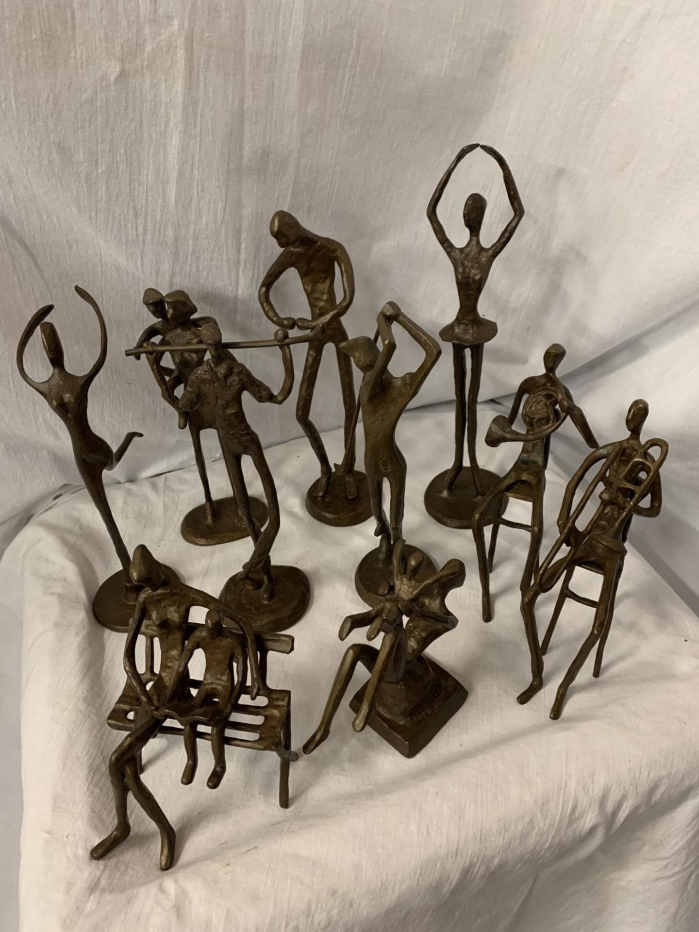 A GROUP OF TEN BRONZE FIGURINES IN THE ABSTRACT FORM