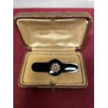 A 9 CARAT GOLD MOUNTED JET BROOCH WITH SEED PEARL ROSETTE