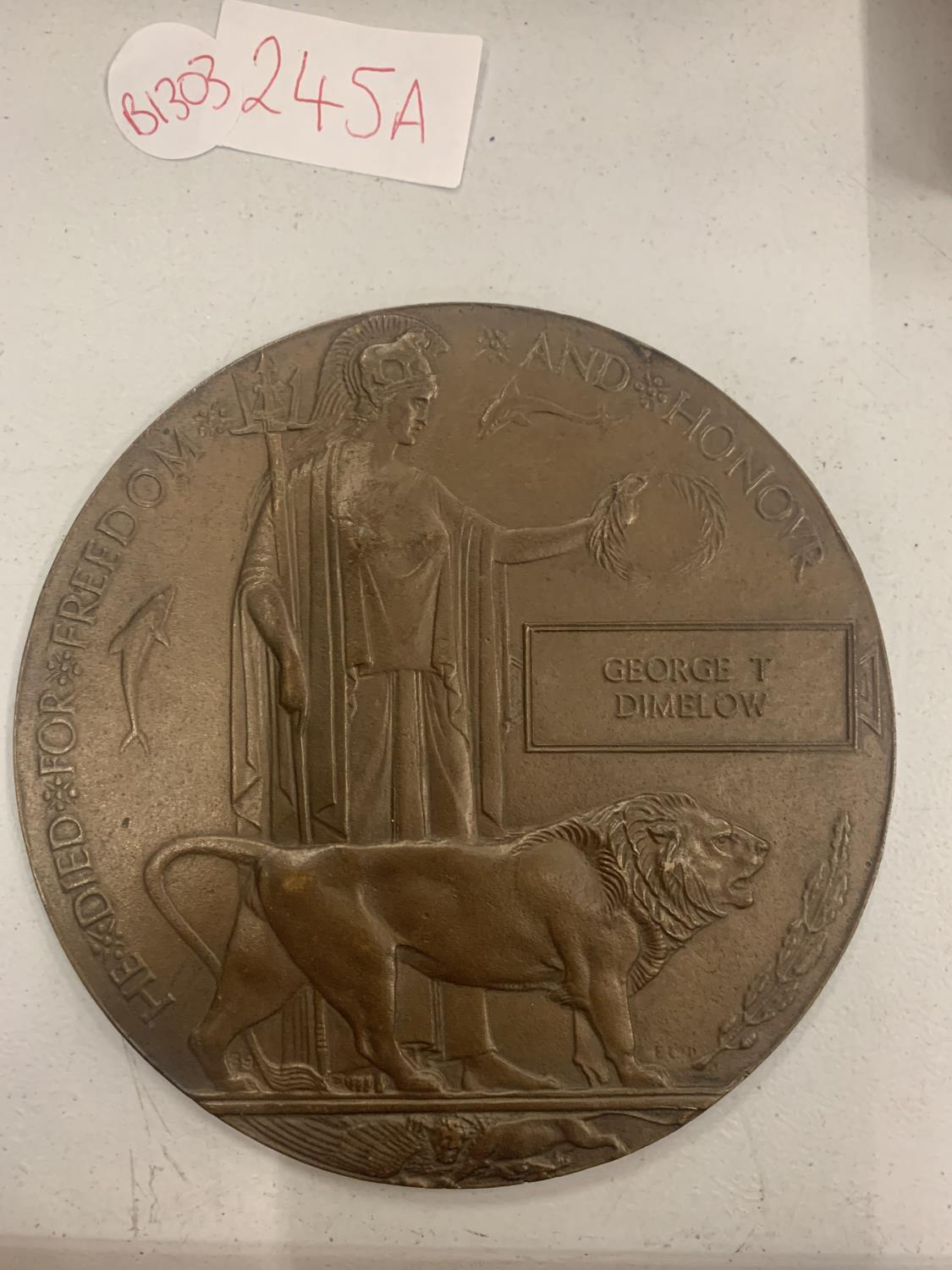 A BRONZE WW1 DEATH PLAQUE 'HE DIED FOR FREEDOM AND HONOUR GEORGE T DIMELOW' 12CM DIAMETER