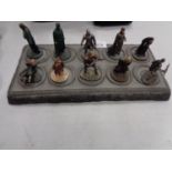 A COLLECTION OF TEN LORD OF THE RINGS FIGURES ON A DISPLAY STAND