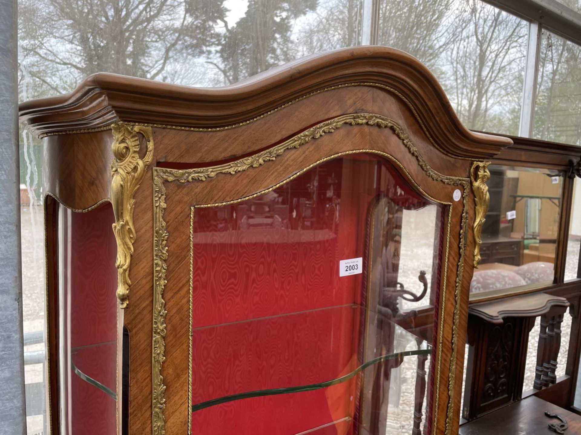 A LOUIS XVI STYLE WALNUT BOWFRONTED DISPLAY CABINET WITH PAINTED PANELS AND APPLIED GILT METAL