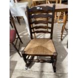 A REPRODUCTION LADDER BACK ROCKING CHAIR WITH A RUSH SEAT