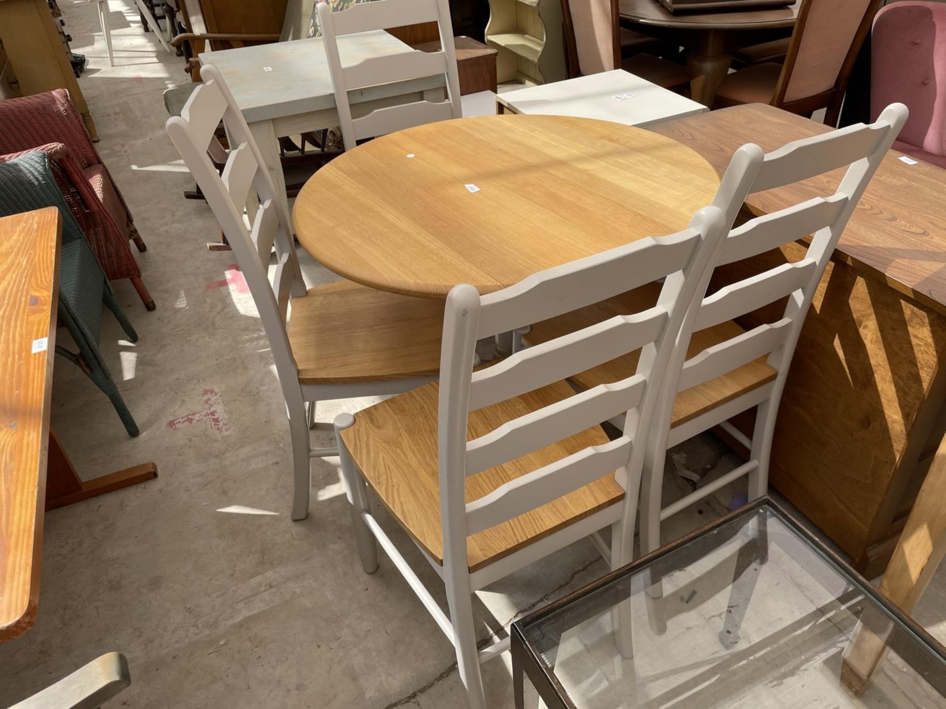 A MODERN CIRCULAR DROP LEAF DINING TABLE, 35" DIAMETER, WITH PAINTED BASE AND FOUR LADDERBACK CHAIRS