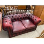 AN OXBLOOD TWO SEATER CHESTERFIELD SETTEE