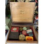 A VINTAGE PINE BOX WITH BRASS DETAIL CONTAINING ELEVEN VINTAGE TINS