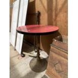 A RED FORMICA TOPPED BAR TABLE WITH A HEAVY CIRCULAR BASE
