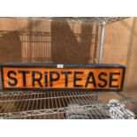 AN ILLUMINATED 'STRIPTEASE' SIGN