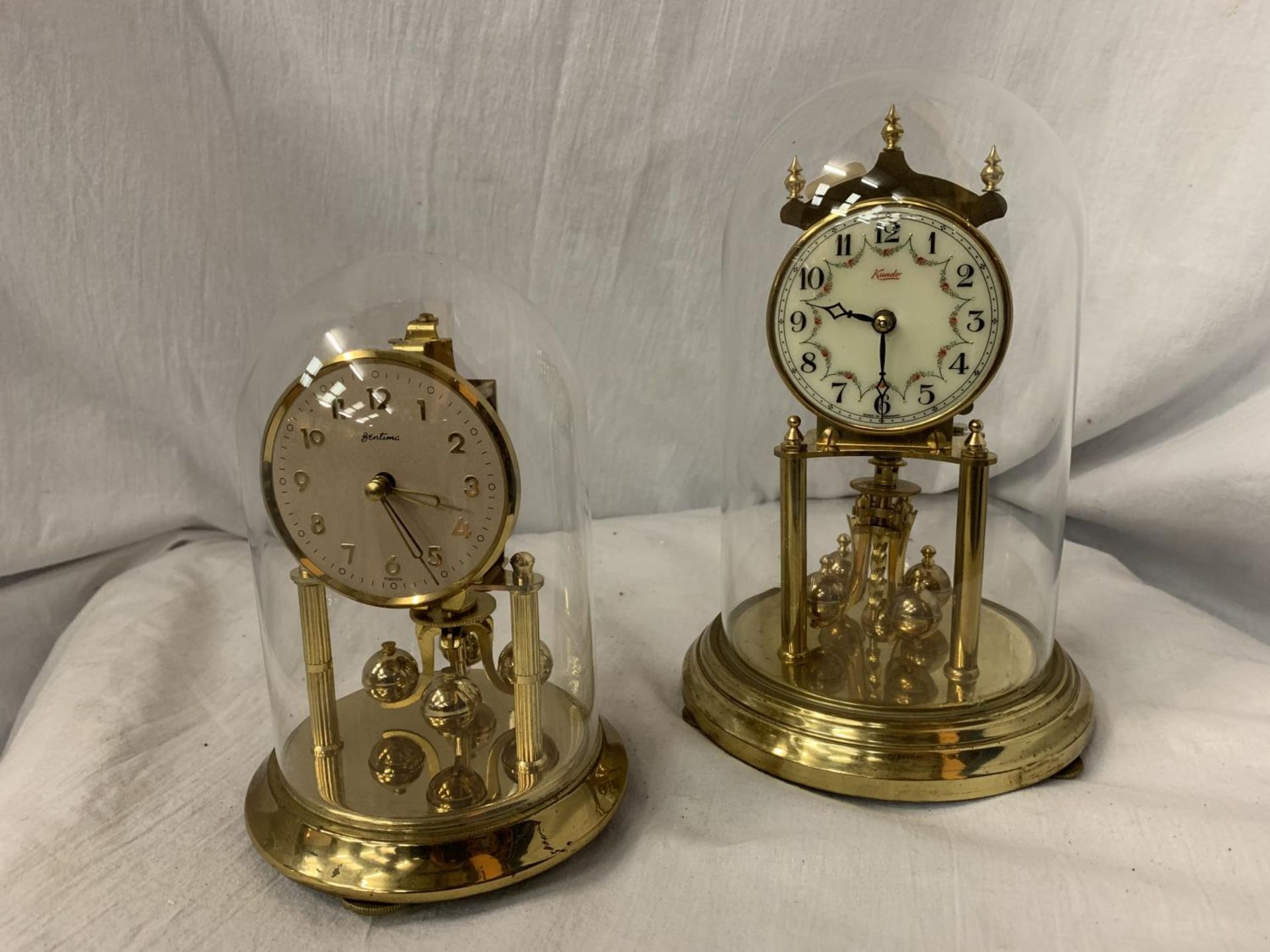 A KUNDO ANNIVERSARY GLASS DOMED CLOCK H: 9" AND A BENTIMA GLASS DOMED CLOCK