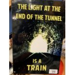 A METAL SIGN"THE LIGHT AT THE END OF THE TUNNEL IS A TRAIN"
