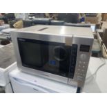 A SILVER PANASONIC MICROWAVE BELIEVED IN WORKING ORDER BUT NO WARRANTY