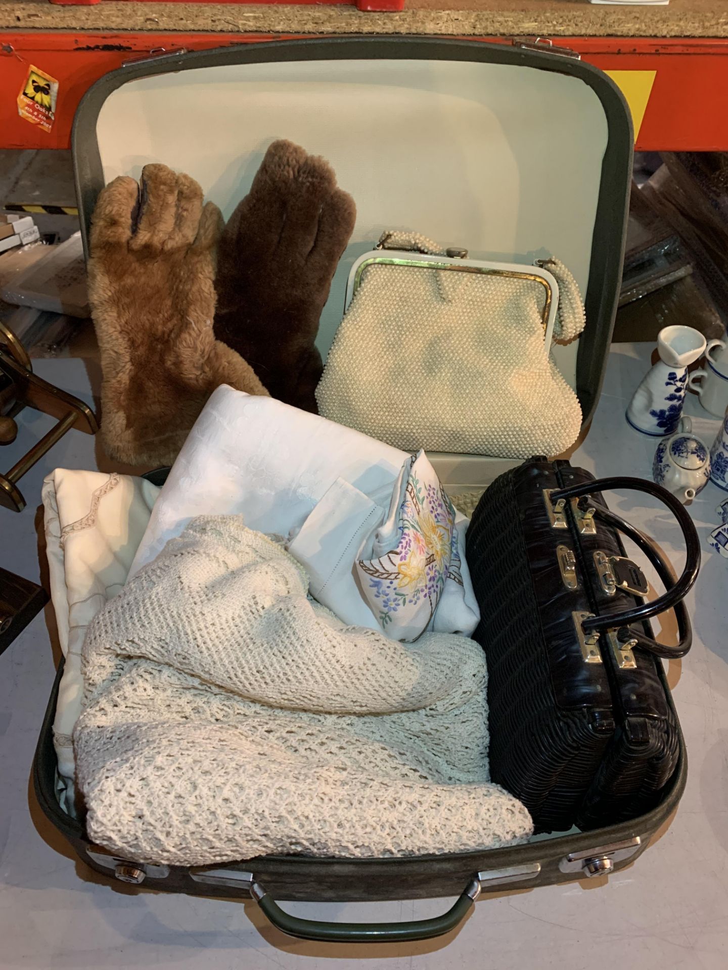 A VINTAGE SUITCASE CONTAINING LINEN, FUR MITTENS AND TWO VINTAGE HAND BAGS, ONE MADE IN BRITISH HONG