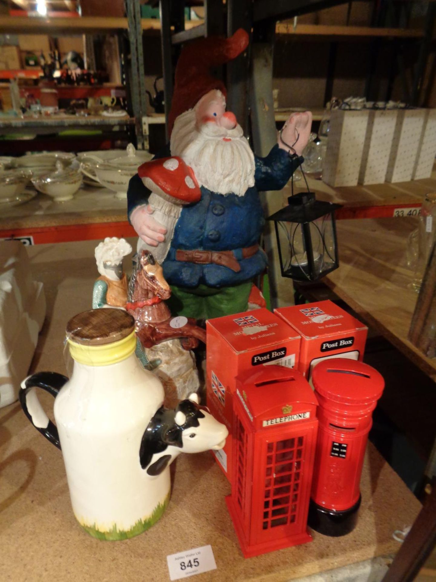 A LARGE GARDEN GNOME, TWO JULIANA MONEY BOXES, A JUG IN THE FORM OF A COW AND A STORAGE JAR IN THE
