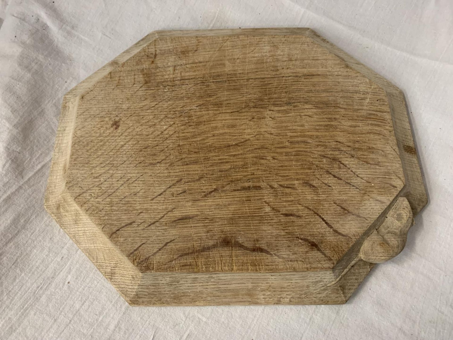 A ROBERT THOMPSON "MOUSEMAN" CARVED OAK CHOPPING/SERVING BOARD WITH MOUSE INSIGNIA 30.5CM X 25CM