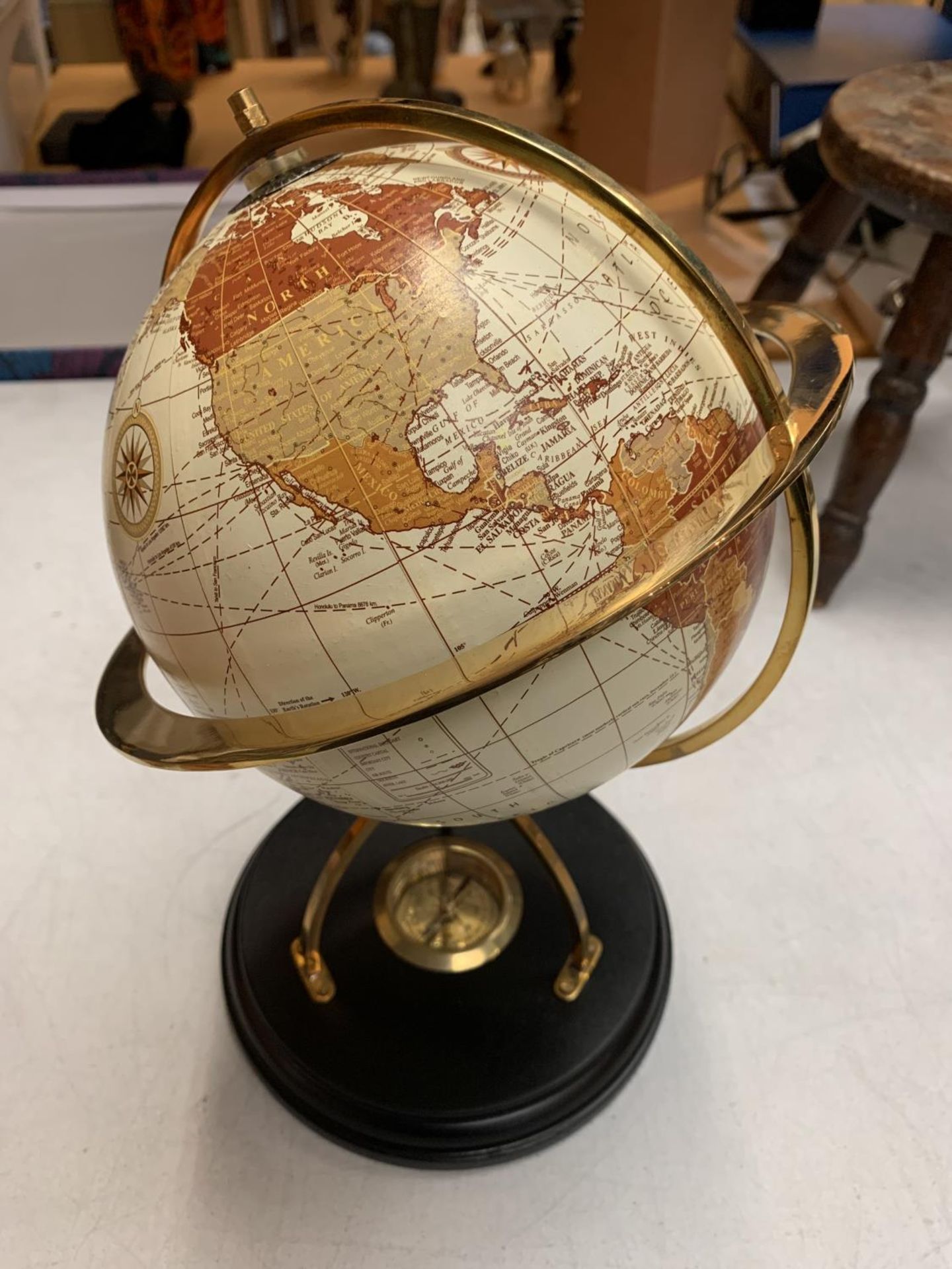 A DECORATIVE DESK GLOBE WITH BRASS DETAIL AND INTEGRATED COMPASS IN THE BASE H: APPROXIMATELY 31CM - Image 2 of 3