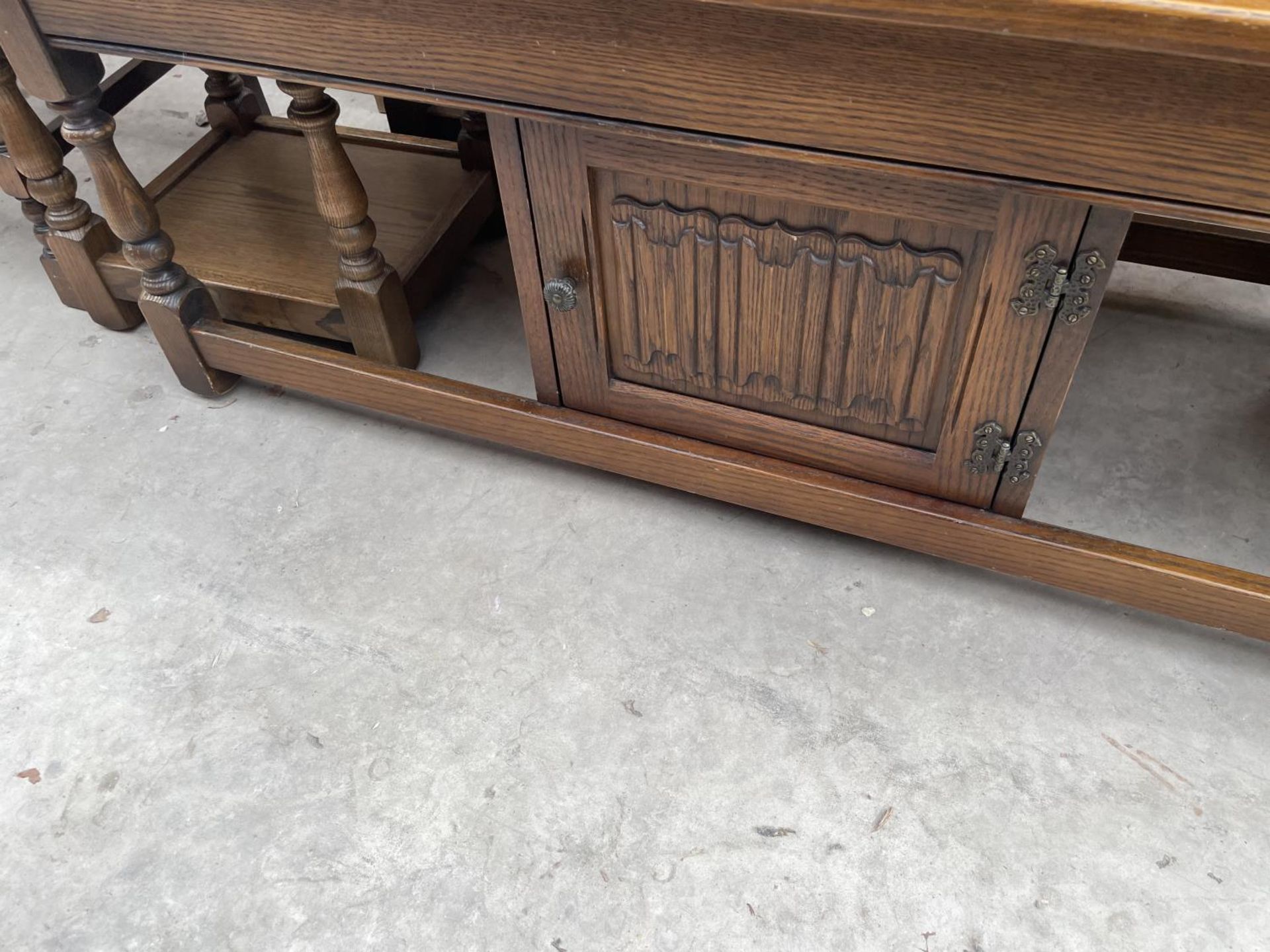 AN OAK OLD CHARM COFFEE TABLE/NEST WITH CENTRAL LINEN FOLD CUPBOARD - Image 4 of 5