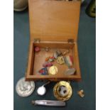 A SMALL TREEN BOX OF ASSORTED ITEMS TO INCLUDE WHISTLE, PIN BADGES, COMMEMORATIVE COINS ETC