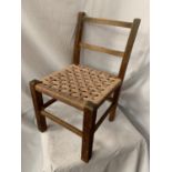 A CHILD'S RUSH SEATED WOODEN CHAIR