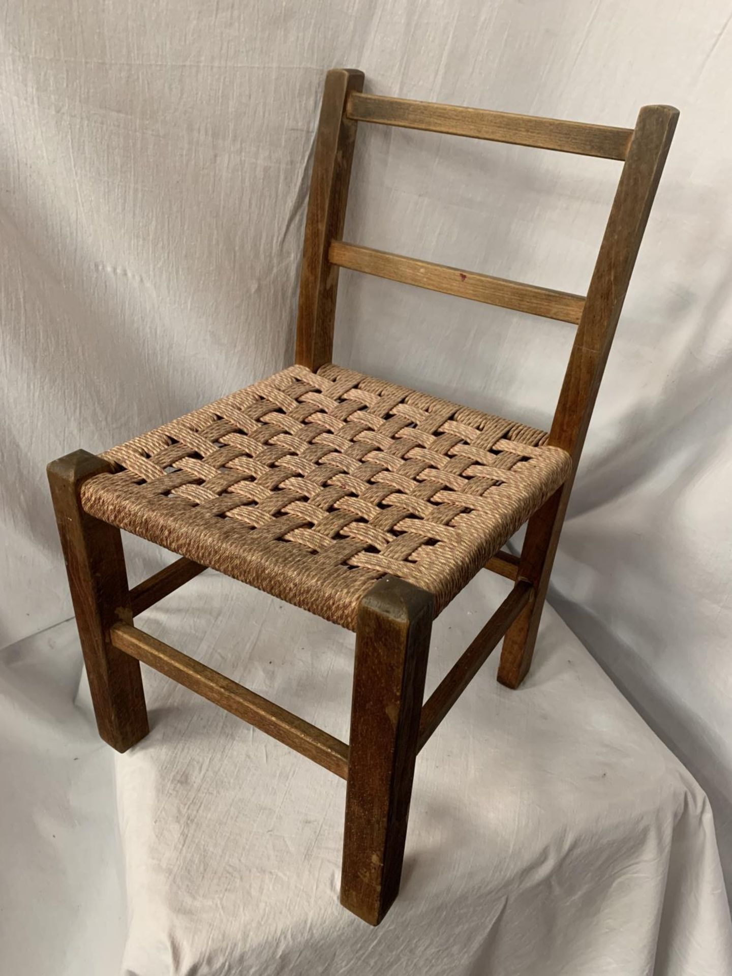 A CHILD'S RUSH SEATED WOODEN CHAIR