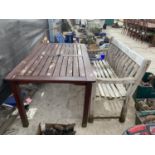 A RECTANGULAR TEAK TABLE AND A WOODEN SLATTED GARDEN BENCH