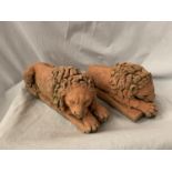 A PAIR OF TERRACOTTA DOORSTOPS/BOOKENDS IN THE FORM OF LIONS L:30CM