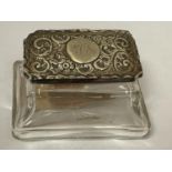 A GLASS TRINKET BOX WITH AN ORNATE SILVER LID