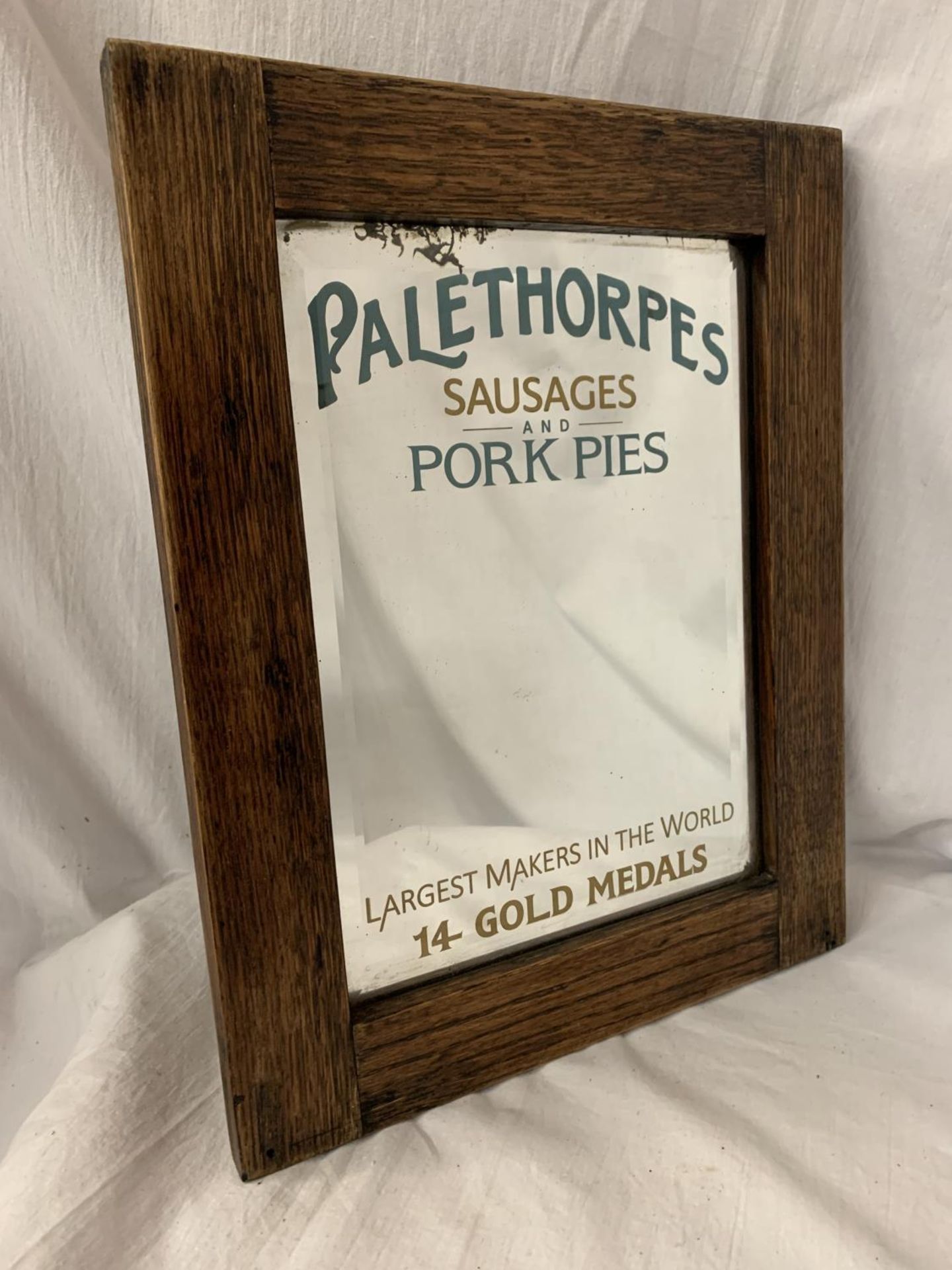 A WOODEN FRAMED ARTS AND CRAFTS STYLE ADVERTISING MIRROR FOR 'PALETHORPES SAUSAGES AND PORK PIES'