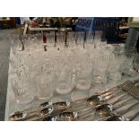 A LARGE QUANTITY OF CUT GLASS TO INCLUDE SHERRY AND PORT GLASSES AND CHAMPAGNE FLUTES