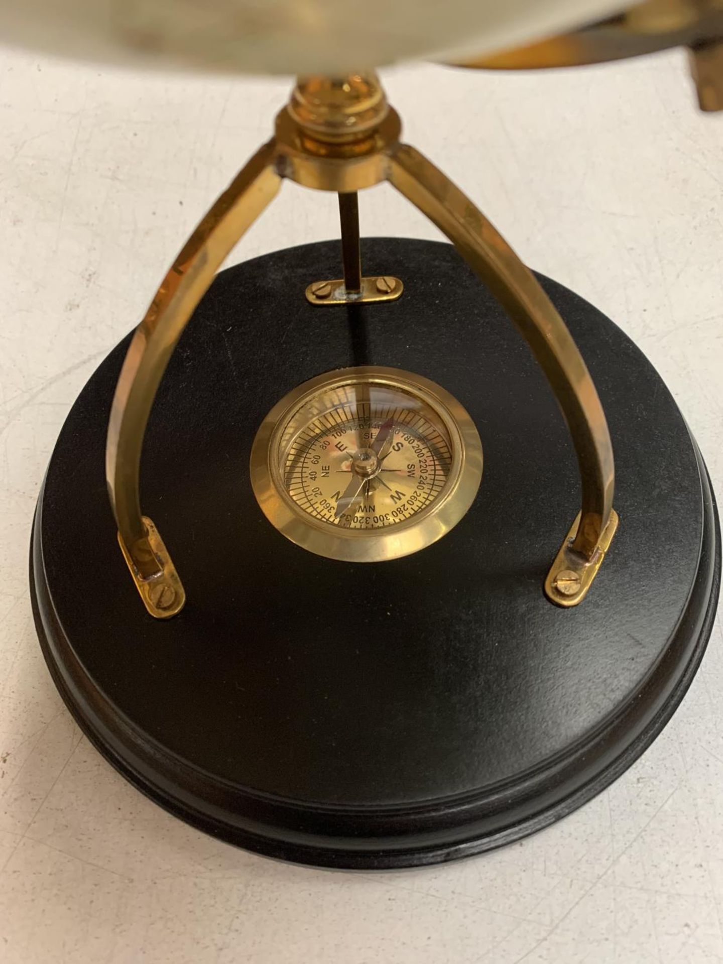 A DECORATIVE DESK GLOBE WITH BRASS DETAIL AND INTEGRATED COMPASS IN THE BASE H: APPROXIMATELY 31CM - Image 3 of 3