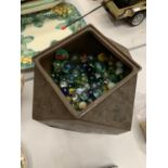 A VINTAGE METAL TIN CONTAINING A LARGE QUANTITY OF MARBLES