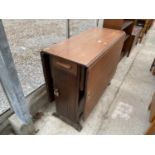 AN EARLY 20TH CENTURY OAK DROP LEAF TABLE WITH END DRAWERS AND CUPBOARD