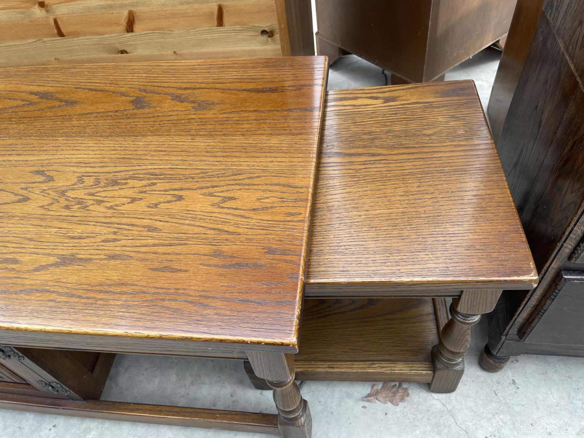 AN OAK OLD CHARM COFFEE TABLE/NEST WITH CENTRAL LINEN FOLD CUPBOARD - Image 2 of 5