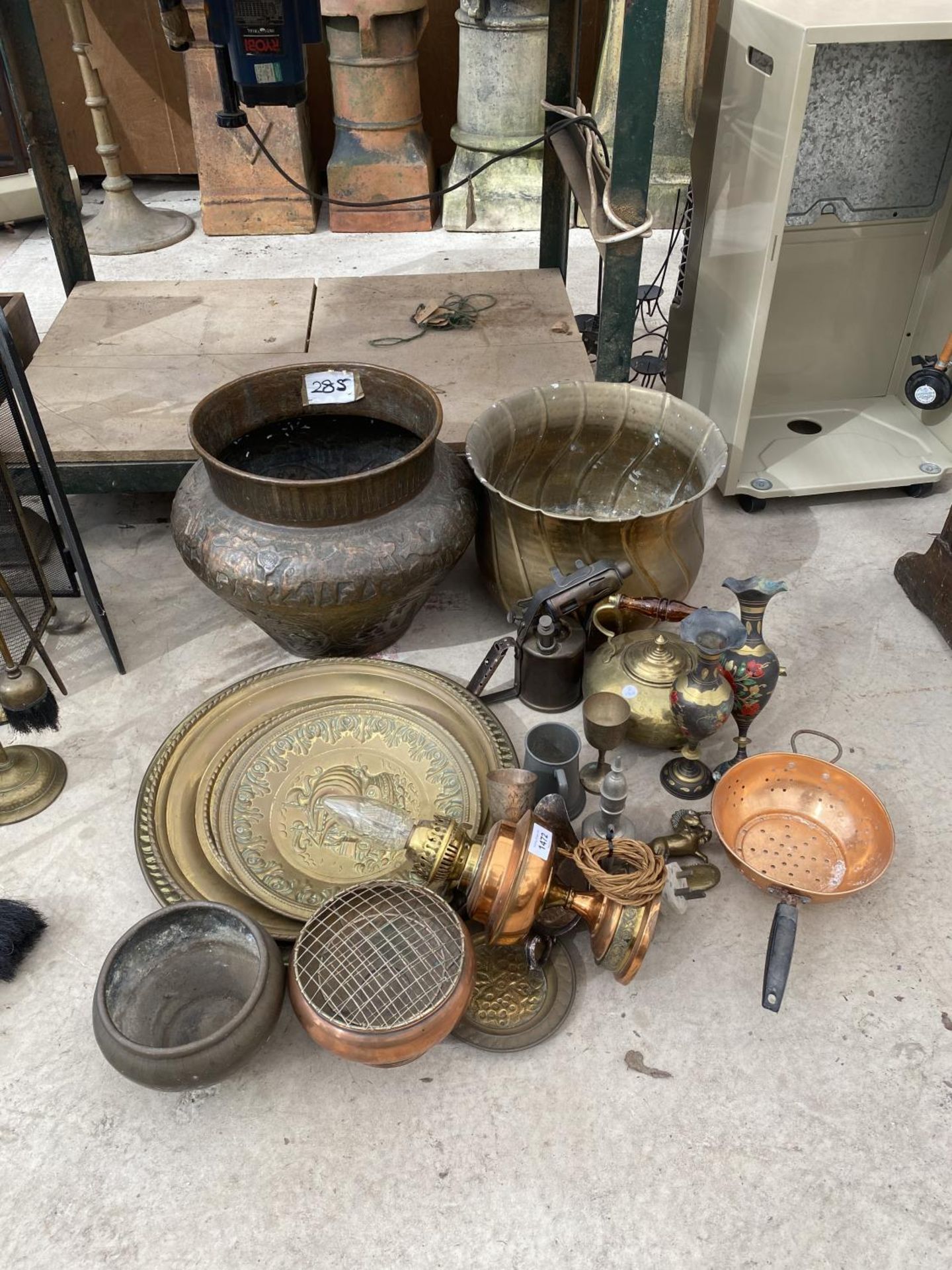 A LARGE QUANTITY OF BRASS WARE TO INCLUDE CHARGERS, AN OIL LAMP AND PLANTERS ETC