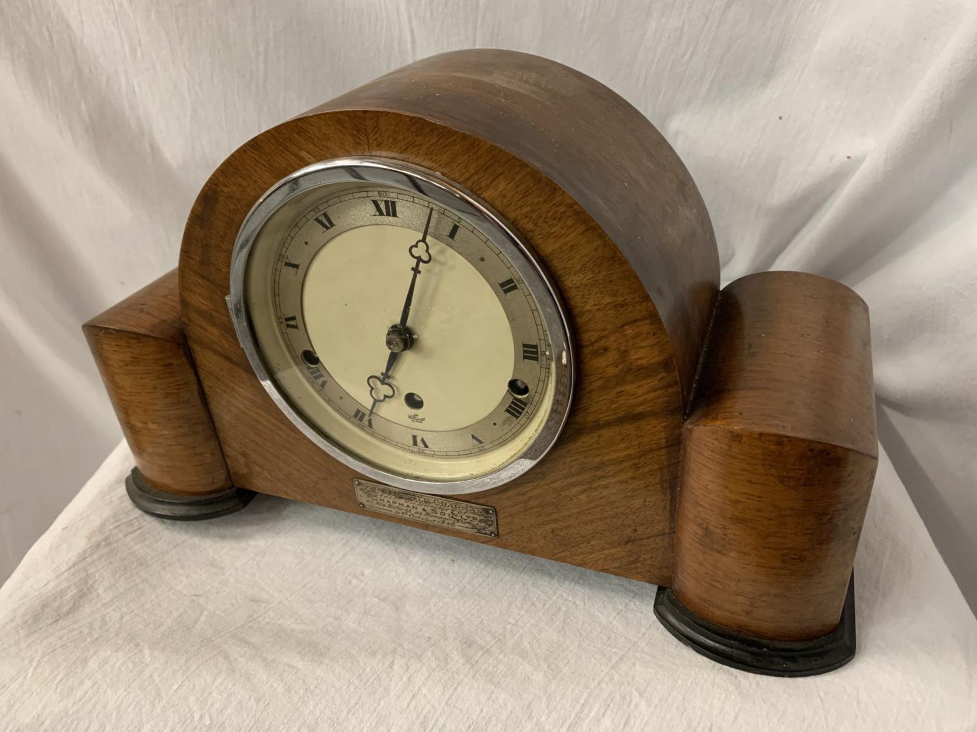 AN ART DECO EIGHT DAY STRIKING WALNUT MANTEL CLOCK WITH PRESENTATION PLAQUE AND KEY