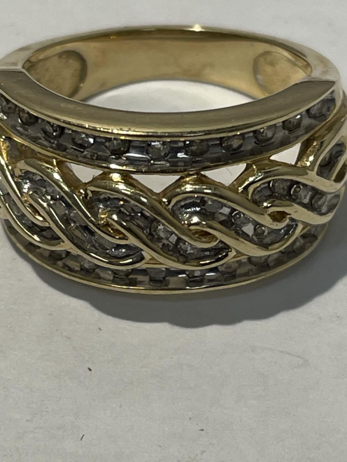 A 9 CARAT YELLOW GOLD RING WITH 1 CARAT OF DIAMONDS WITH A TWIST DESIGN SIZE N/O - Image 4 of 4