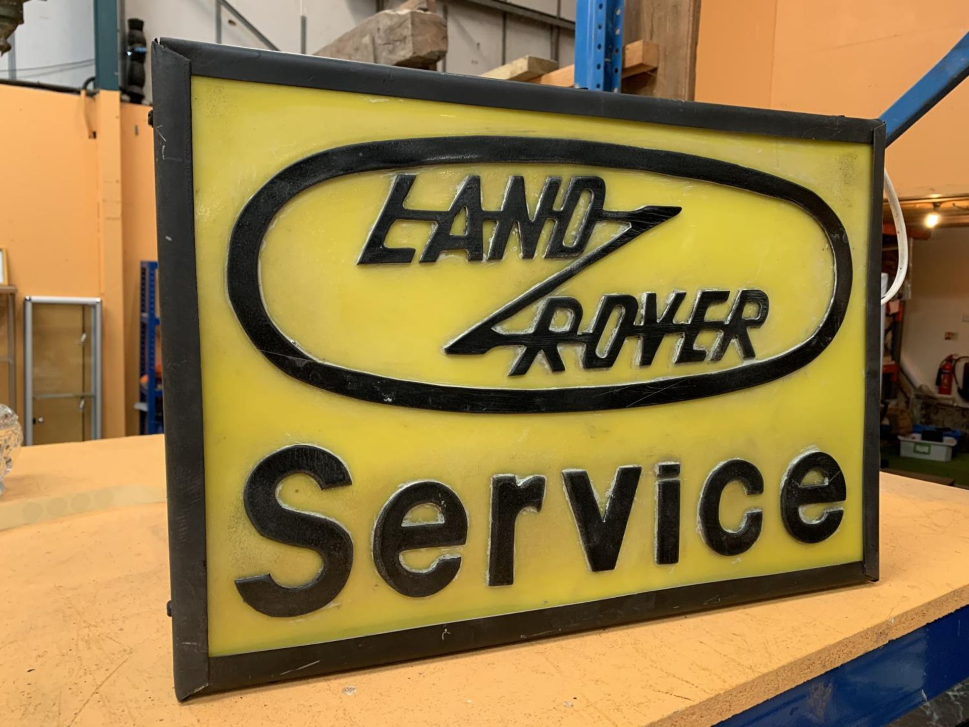 AN ILLUMINATED ' LAND ROVER SERVICE' SIGN