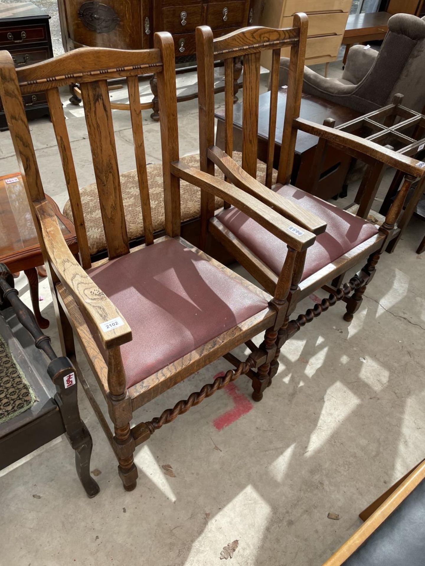 A PAIR OF EARLY 20TH CENTURY OAK JACOBEAN STYLE ELBOW CHAIRS WITH BARLEYTWIST FRONT STRETCHERS