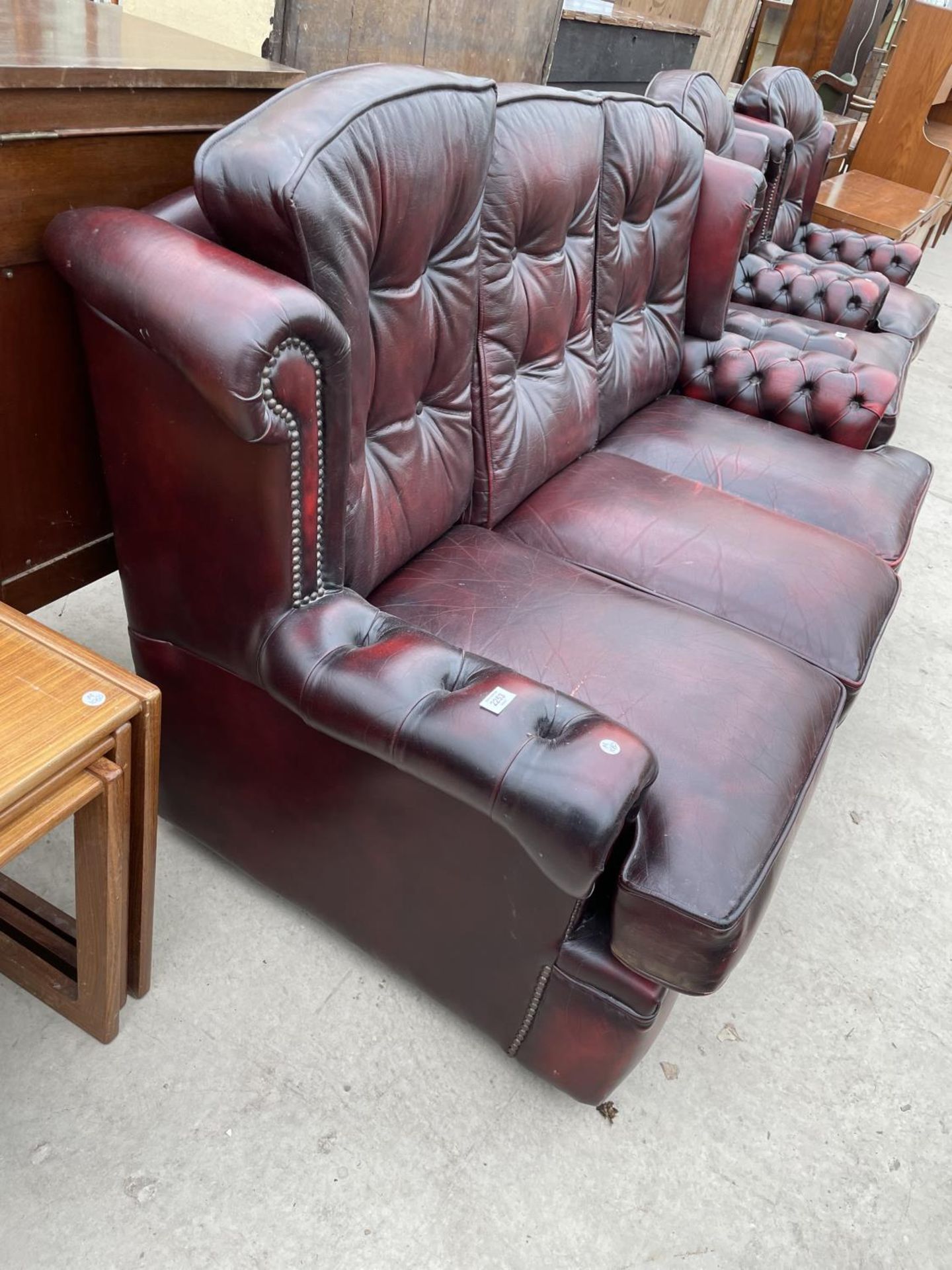 AN OXBLOOD LEATHER THREE SEATER SOFA WITH BUTTONED BACK AND ARMS - Image 6 of 6