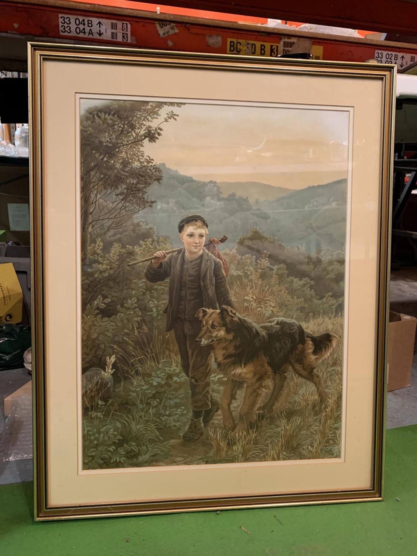 A GILT FRAMED PRINT DEPICTING A BOY WITH DOG