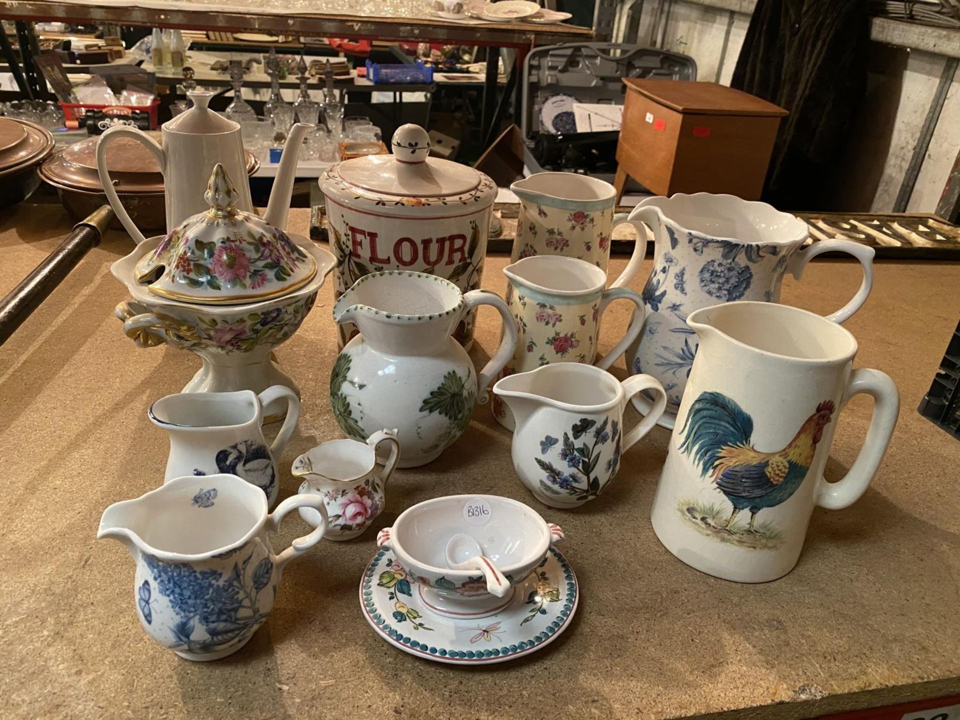 SEVERAL MEDIUM AND LARGE JUGS IN DIFFERENT DECORATIVE STYLES, A SMALL BOWL AND A FLOUR STORAGE JAR