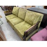 AN EDWARDIAN BERGERE THREE SEATER SETTEE ON BALL AND CLAW FEET