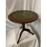 A SMALL CIRCULAR MAHOGANY SIDE TABLE WITH INLAID GREEN LEATHER TOP H:48CM