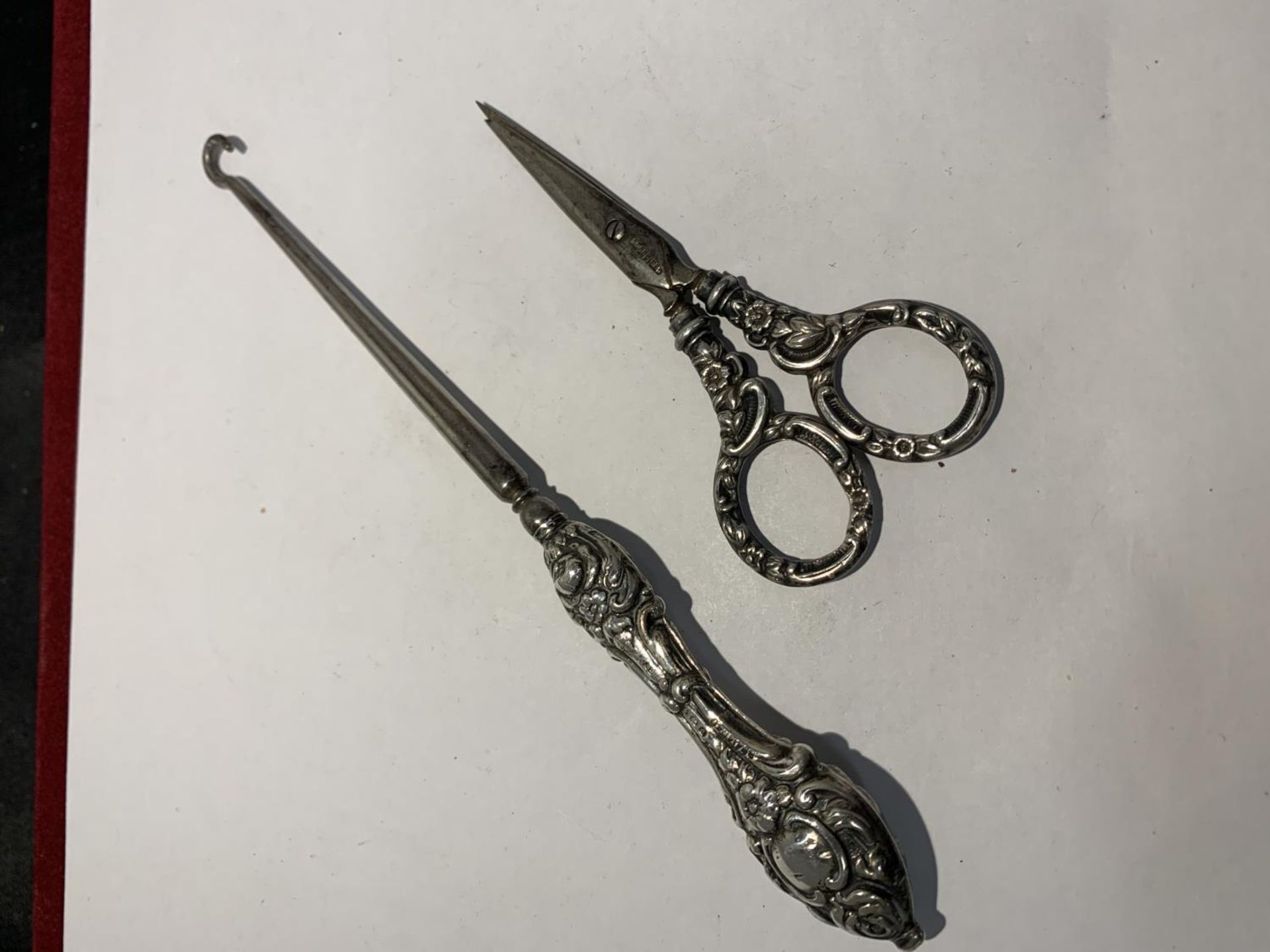 A SILVER HANDLED BUTTON HOOK AND A PAIR OF SILVER HANDLED SISSORS