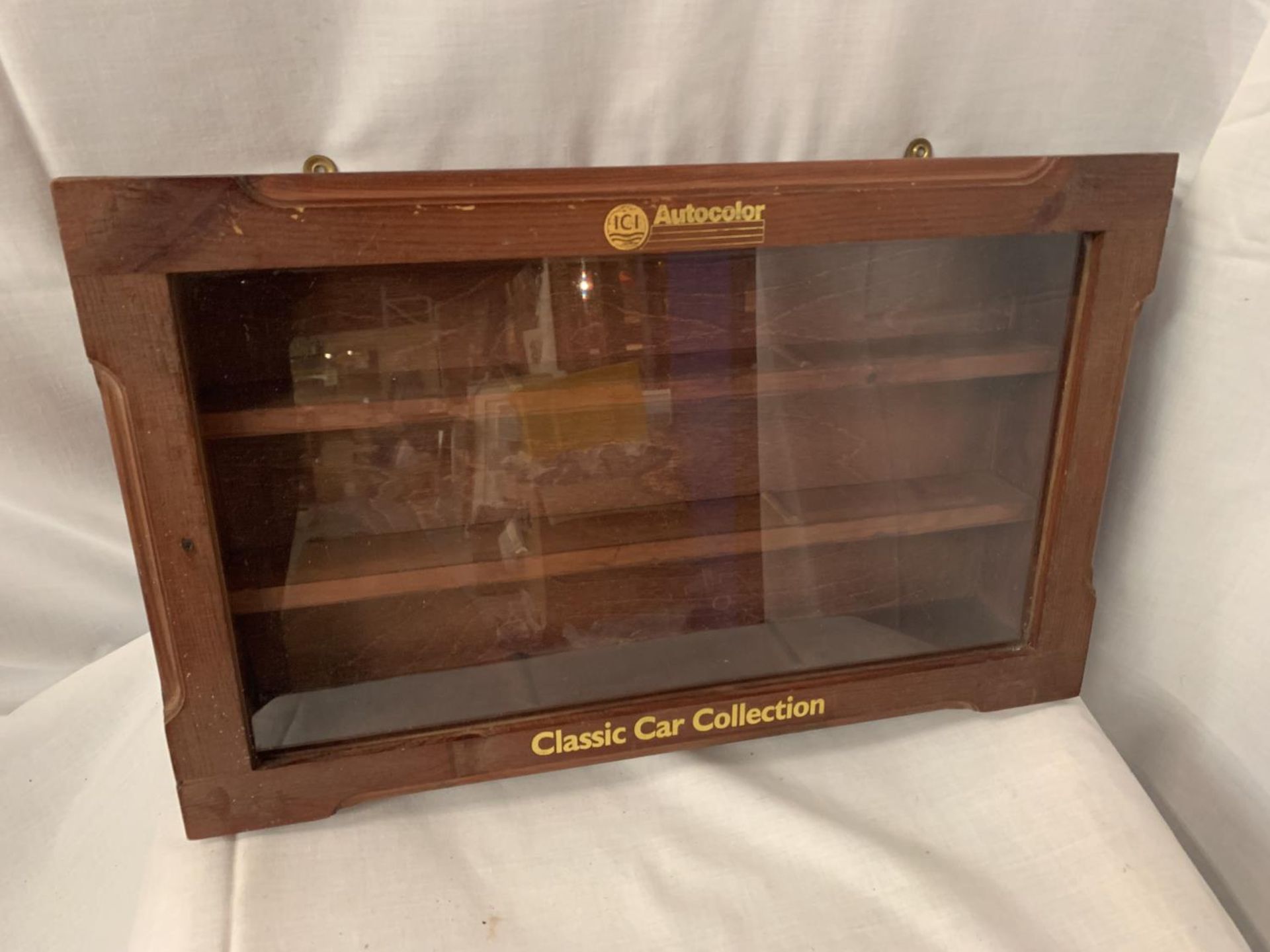 A WOODEN TOY CAR DISPLAY CABINET WITH GLASS FRONT