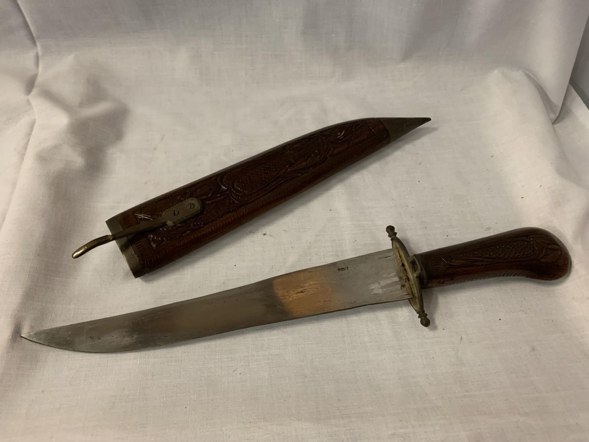 A HARDWOOD HANDLED INDIAN KNIFE TO ALSO INCLUDE THE CARVED WOODEN CASE L: 39CM