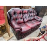 AN OXBLOOD BUTTON-BACK THREE SEATER SETTEE